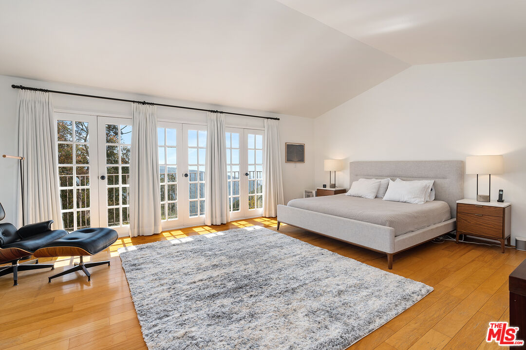 2382 Live Oak Meadows Road Malibu, CA 90265 - Photo 23 of 50 a bedroom with a bed and glass window