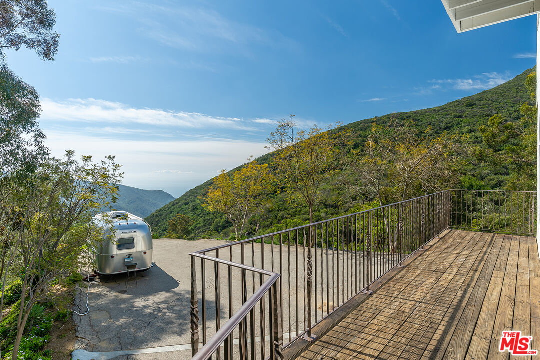 2382 Live Oak Meadows Road Malibu, CA 90265 - Photo 43 of 50 a view of a balcony with wooden floor and fence