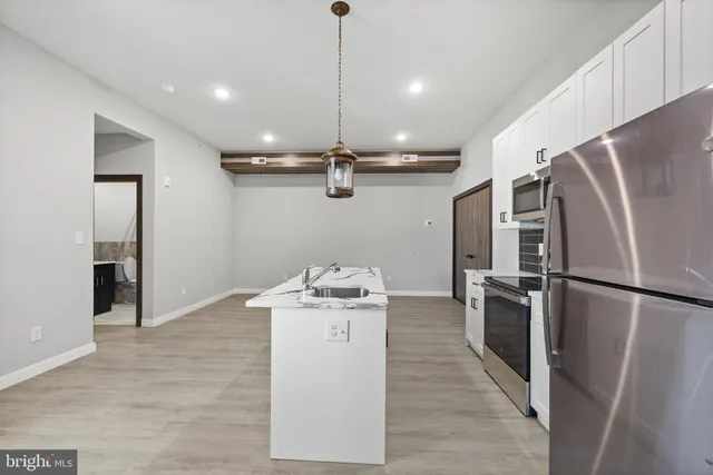 a kitchen with stainless steel appliances granite countertop a refrigerator a stove and a sink