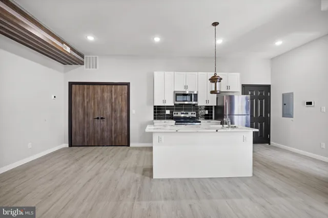 a kitchen with stainless steel appliances a refrigerator and a stove top oven