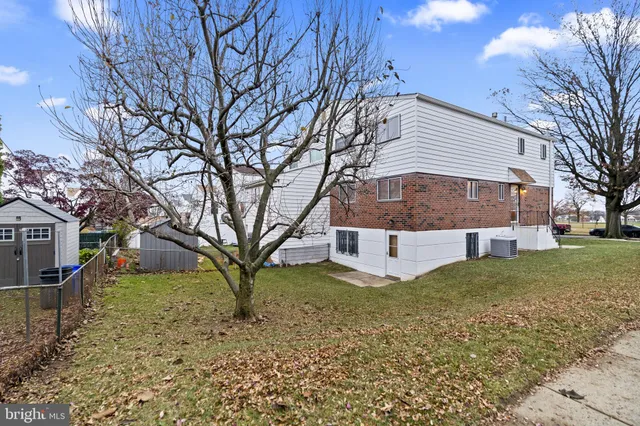 a view of a house with a yard and a tree