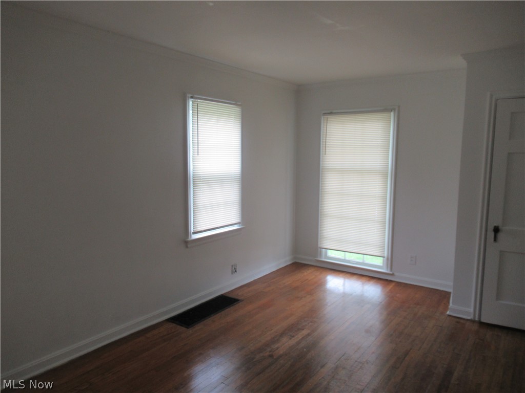 3824 East Antisdale Road Cleveland, OH 44118 - Photo 6 of 27 Room featuring wood-finish flooring, white walls, two windows with blinds, and white trim molding
