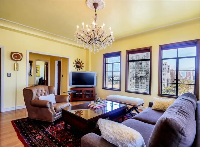 a living room with furniture a chandelier and a flat screen tv