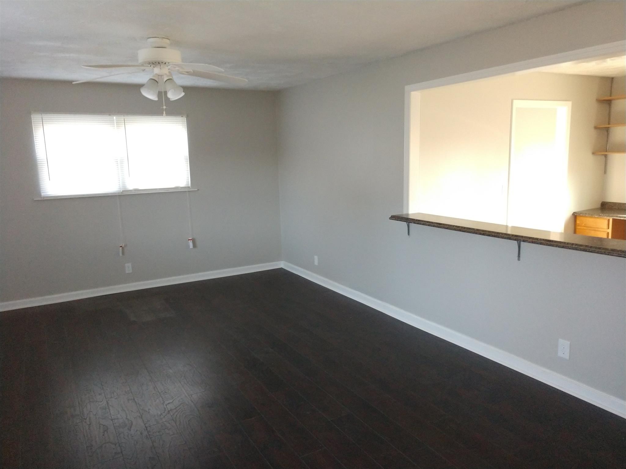 1240 Black Road Cunningham, TN 37052 - Photo 2 of 12 a view of an empty room with wooden floor and a window