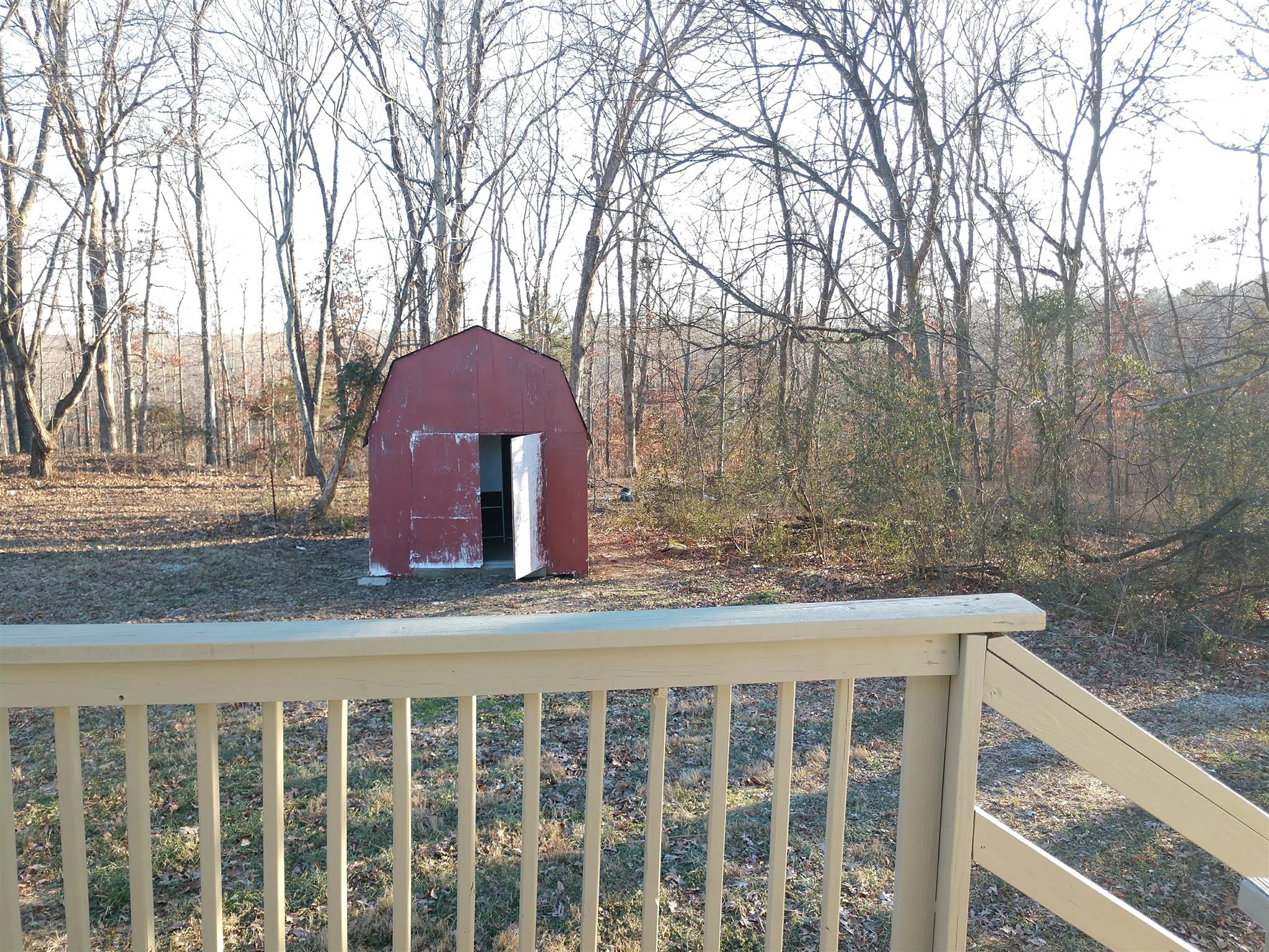 1240 Black Road Cunningham, TN 37052 - Photo 11 of 12 a view of a wooden house with a yard and large trees