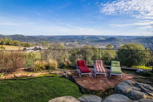 a view of a lake with a chairs in patio