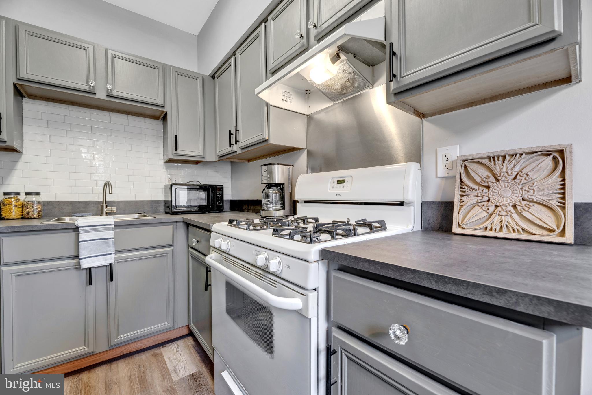 1436 W Street Northwest, Unit 405 Washington, DC 20009 - Photo 6 of 13 a kitchen with stainless steel appliances granite countertop a stove and a sink