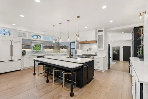 a kitchen with stainless steel appliances granite countertop a sink a stove and a refrigerator