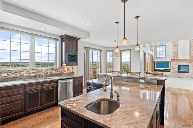 a kitchen with a stove a sink a center island and a wooden floor