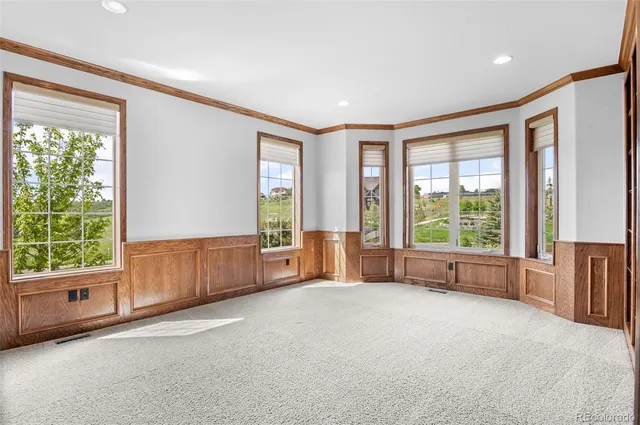 a living room with furniture and large windows with outer view