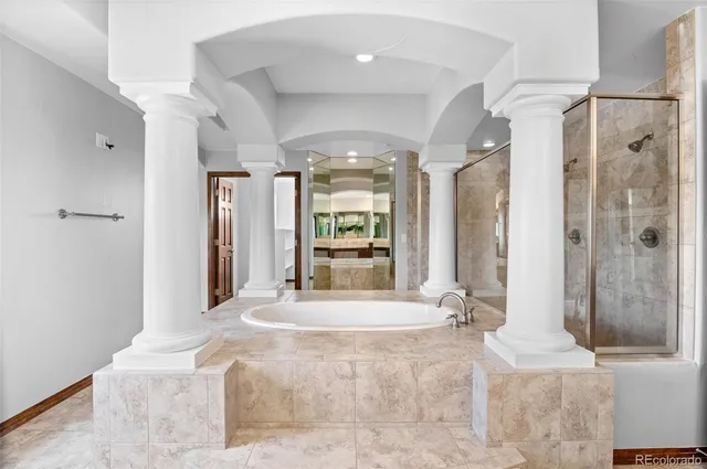 a large white tub sitting in a bathroom next to a window