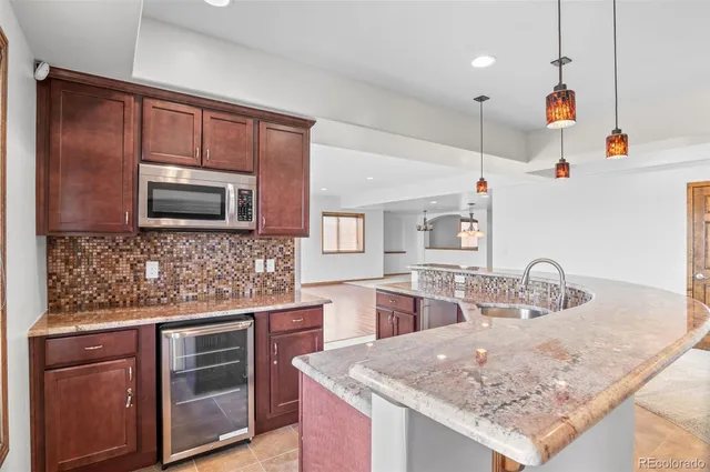 a kitchen with stainless steel appliances granite countertop a sink a stove and a wooden cabinets