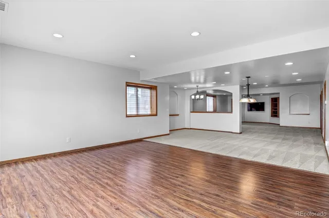 an empty room with windows and chandelier