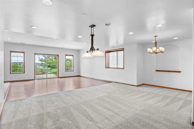 an empty room with windows and fireplace