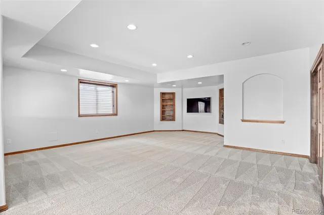 a view of an empty room with a window and fireplace