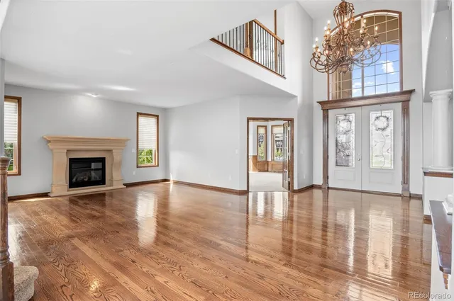 a view of an empty room with wooden floor fireplace and a window