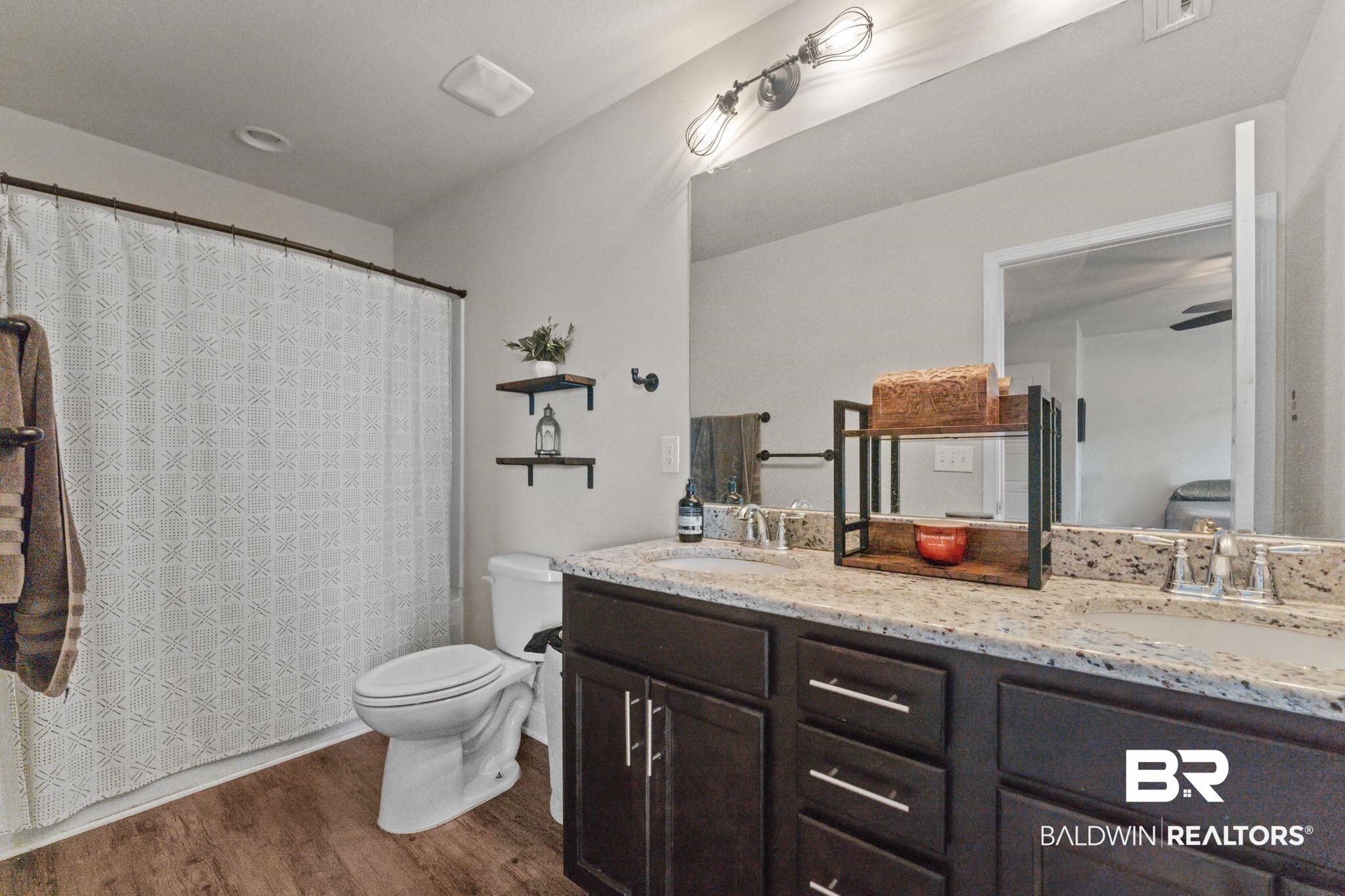 12711 Chickadee Lane Daphne, AL 36527 - Photo 20 of 39 Full bath with dark wood-style floors, double vanity, and a shower with shower curtain