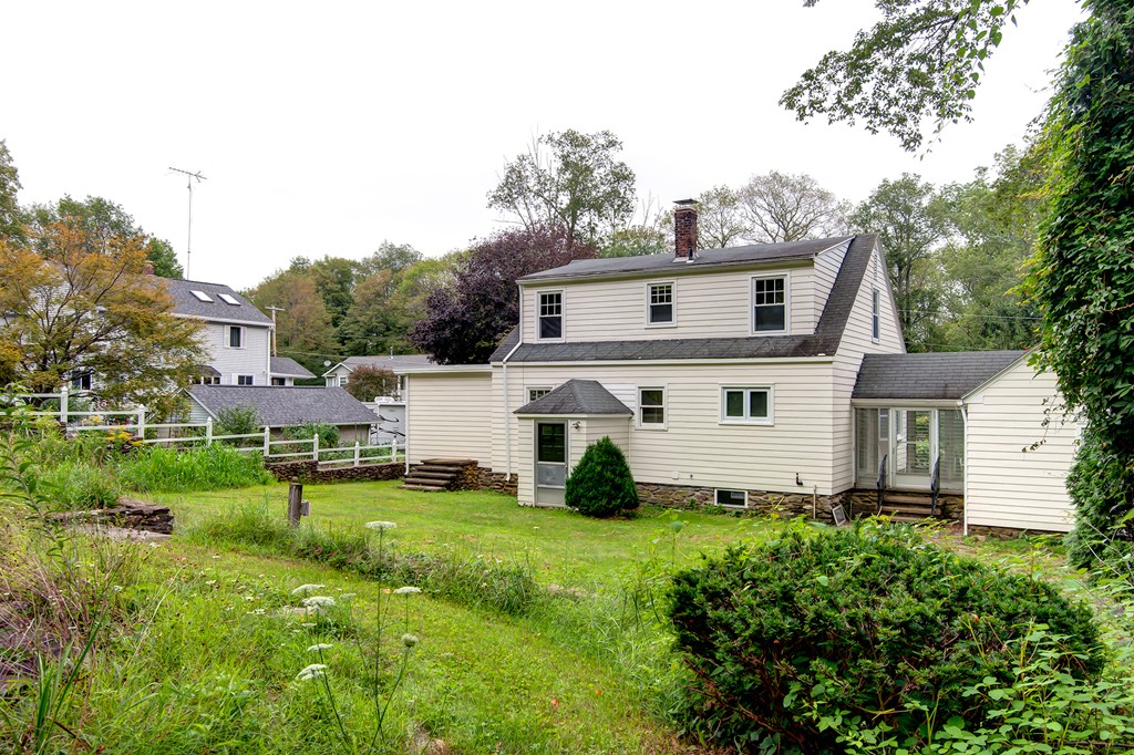 112 Wallace Road Sturbridge, MA 01566 - Photo 5 of 30 a view of a white house in front of a big yard with plants and large trees