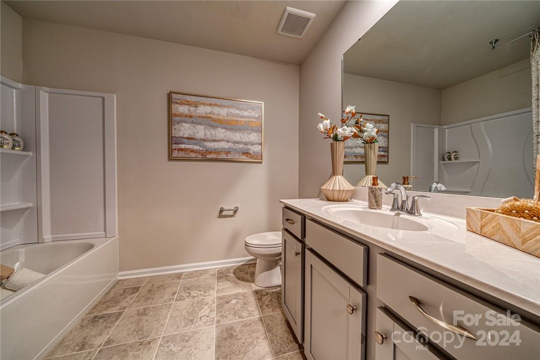 6048 Chelsea Oaks Ridge, Unit 2067 Tega Cay, SC 29708 - Photo 10 of 12 a bathroom with a sink a toilet and tub