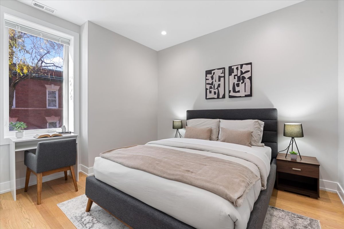 3653 West Barry Avenue, Unit 2W Chicago, IL 60618 - Photo 22 of 27 a bedroom with a bed and a table