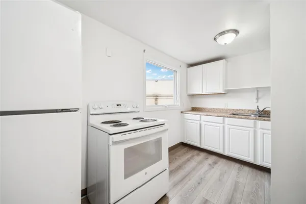 a kitchen with a stove top oven and white cabinets