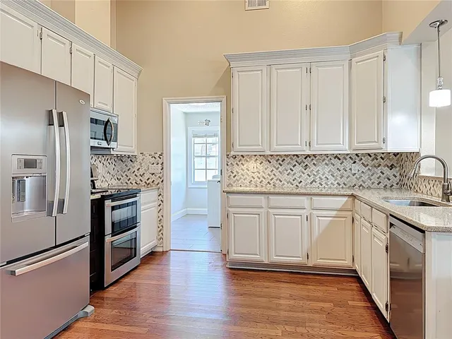 a kitchen with stainless steel appliances granite countertop a stove a sink and a refrigerator