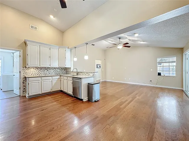 a kitchen with a sink cabinets and wooden floor