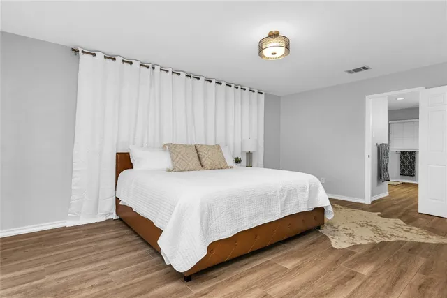 a bedroom with a bed and a wooden floor