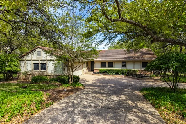 a front view of a house with yard and tree