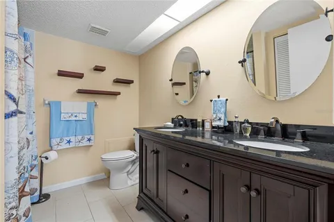 a bathroom with a double vanity sink mirror and toilet