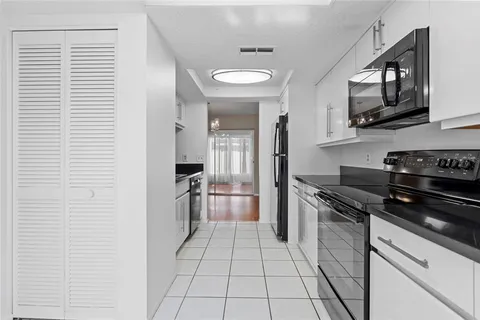 a kitchen with stainless steel appliances granite countertop a refrigerator and a stove top oven