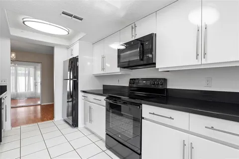 a kitchen with stainless steel appliances granite countertop a refrigerator and a stove top oven