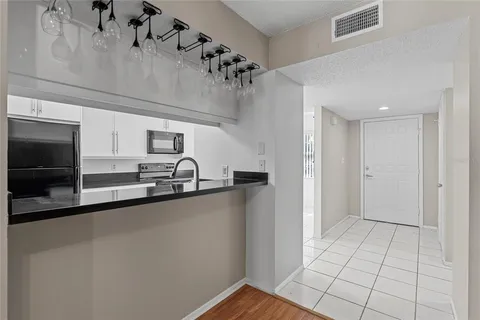 a view of a kitchen with a sink and a refrigerator