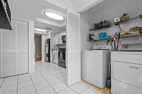 a kitchen with white cabinets and refrigerator