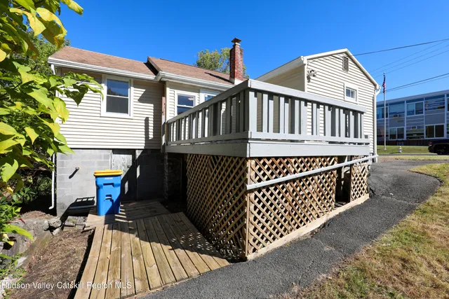 a view of a house with wooden deck front of house
