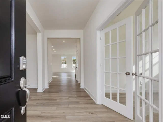 a view of an empty room with wooden floor and windows