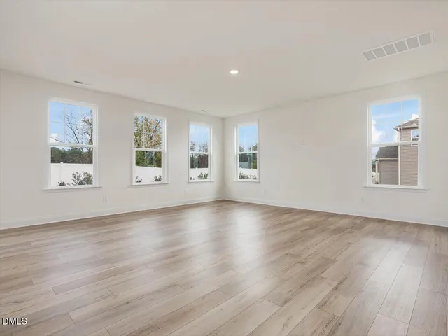 a view of a kitchen with white cabinets and wooden floor