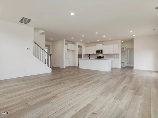 a kitchen with stainless steel appliances granite countertop a sink cabinets and wooden floor