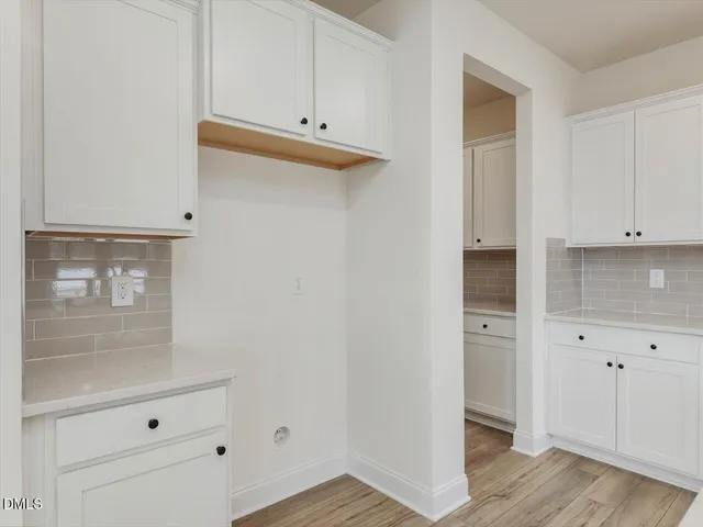 a large kitchen with cabinets wooden floor and stainless steel appliances