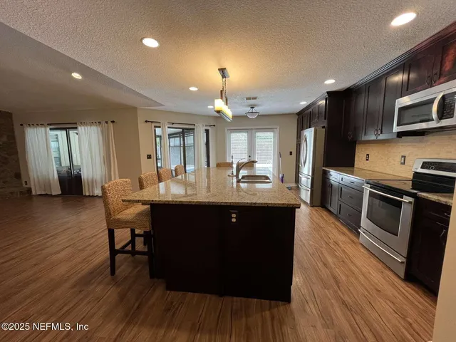 a kitchen with stainless steel appliances wooden floors and wooden cabinets