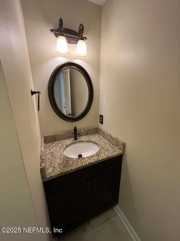a bathroom with a granite countertop sink and a mirror