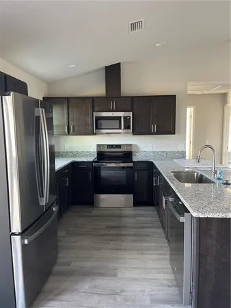 a kitchen with stainless steel appliances granite countertop a sink stove and refrigerator
