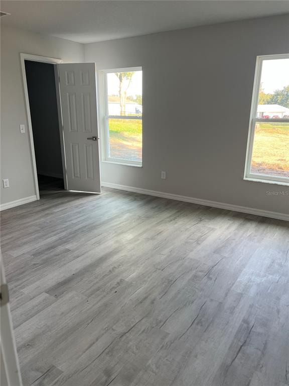 4519 East Walker Street Inverness, FL 34453 - Photo 7 of 8 an empty room with wooden floor and windows