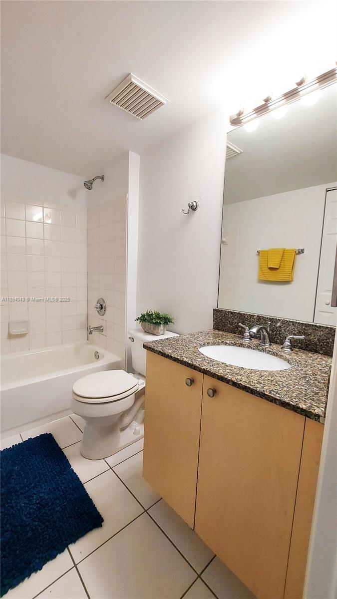 2457 Centergate Drive, Unit 108 Miramar, FL 33025 - Photo 11 of 18 a bathroom with a granite countertop sink a toilet a mirror and bathtub