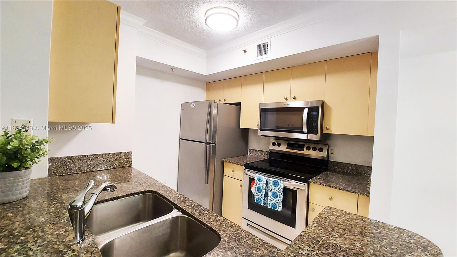 2457 Centergate Drive, Unit 108 Miramar, FL 33025 - Photo 6 of 18 a kitchen with a refrigerator and a sink