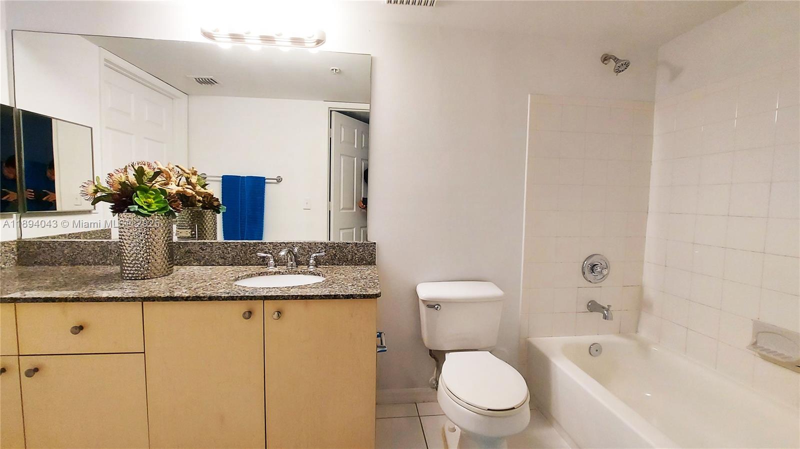 2457 Centergate Drive, Unit 108 Miramar, FL 33025 - Photo 7 of 18 a bathroom with a granite countertop sink mirror vanity and toilet