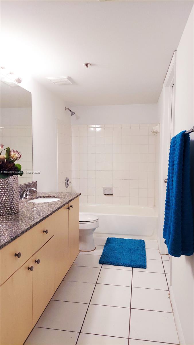 2457 Centergate Drive, Unit 108 Miramar, FL 33025 - Photo 9 of 18 a bathroom with a sink a toilet and a mirror