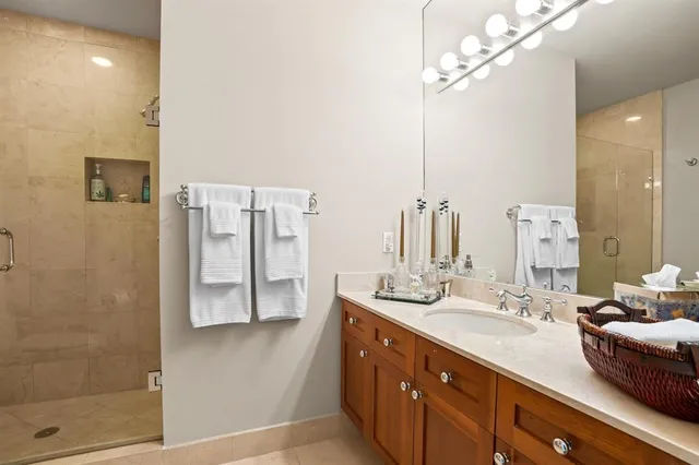 a bathroom with a double vanity sink a mirror and shower