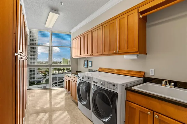 a utility room with sink dryer and washer