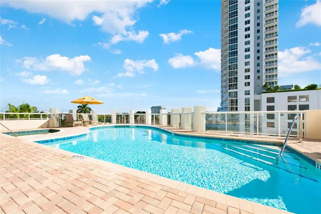 a view of swimming pool with lawn chairs and plants